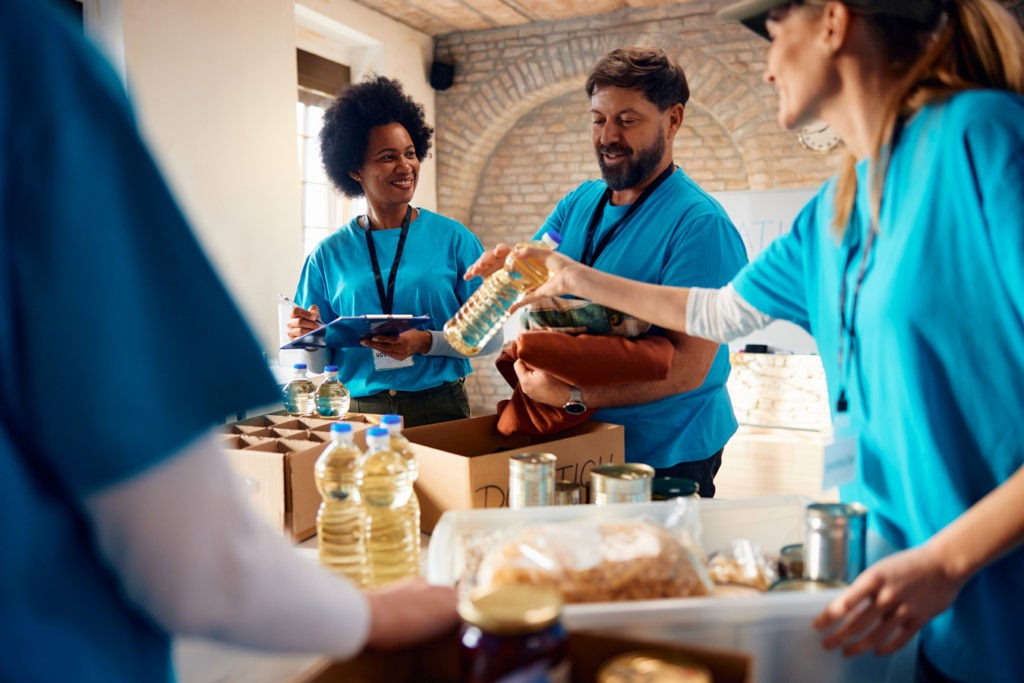 Individuals in blue shirts collaborate and assist one another in a supportive environment.