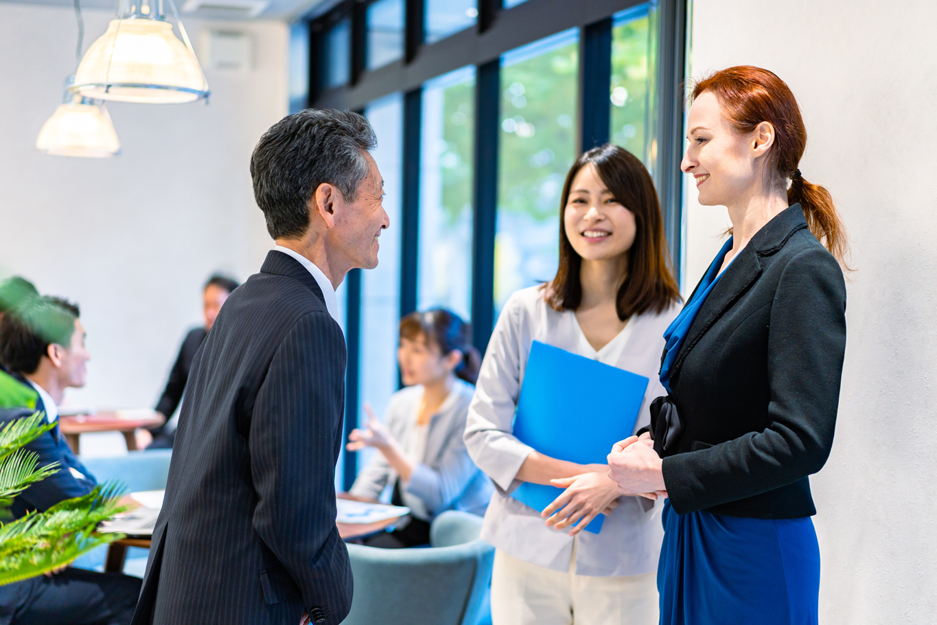 Multicultural business colleagues conversing in a corporate office environment.