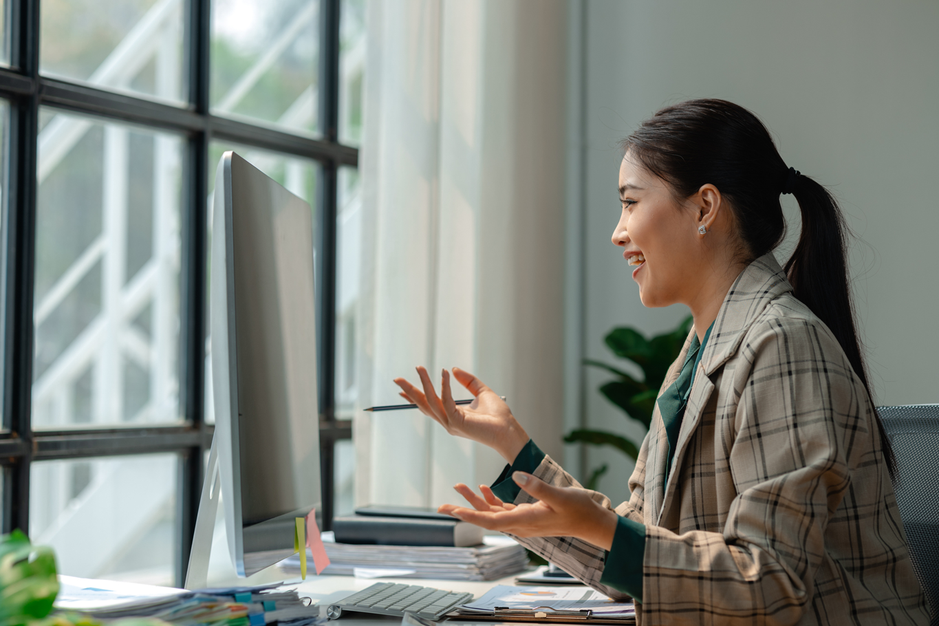 Woman sitting at desk having animated virtual meeting.