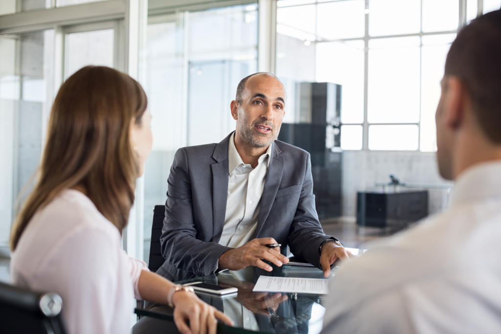 A man in a business suit conversing with two women.