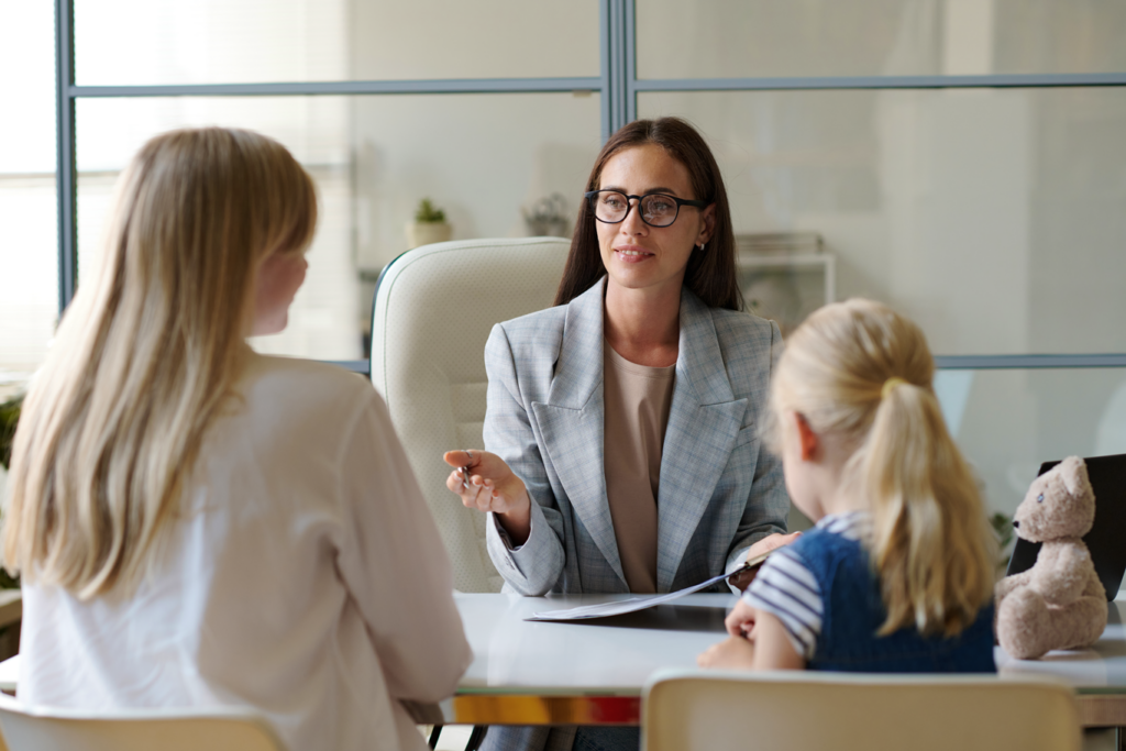 Professional lady speaking to mother with child in office