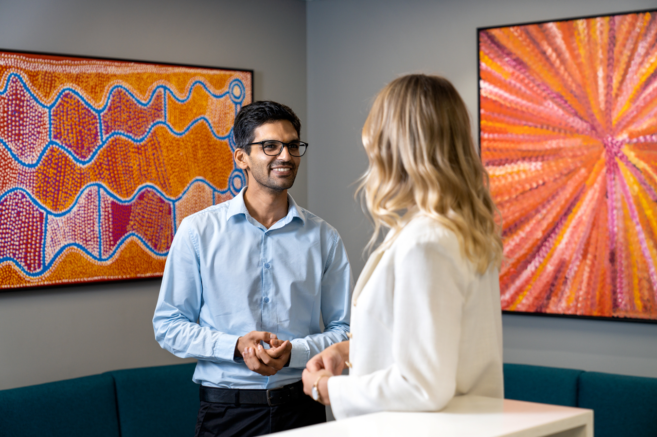 Male and female having conversation in office environment.