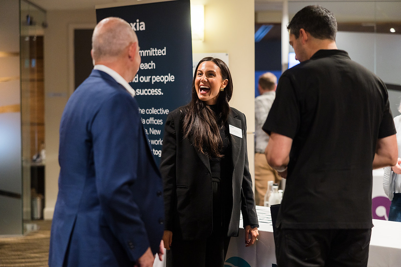 Female Nexia employee greeting colleagues at professional Nexia conference