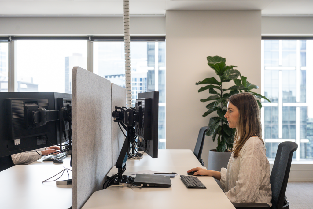 Young female Nexia employee working on computer in modern office