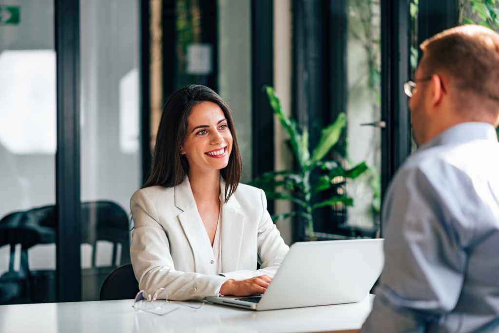 A woman in a business suit converses with a man.