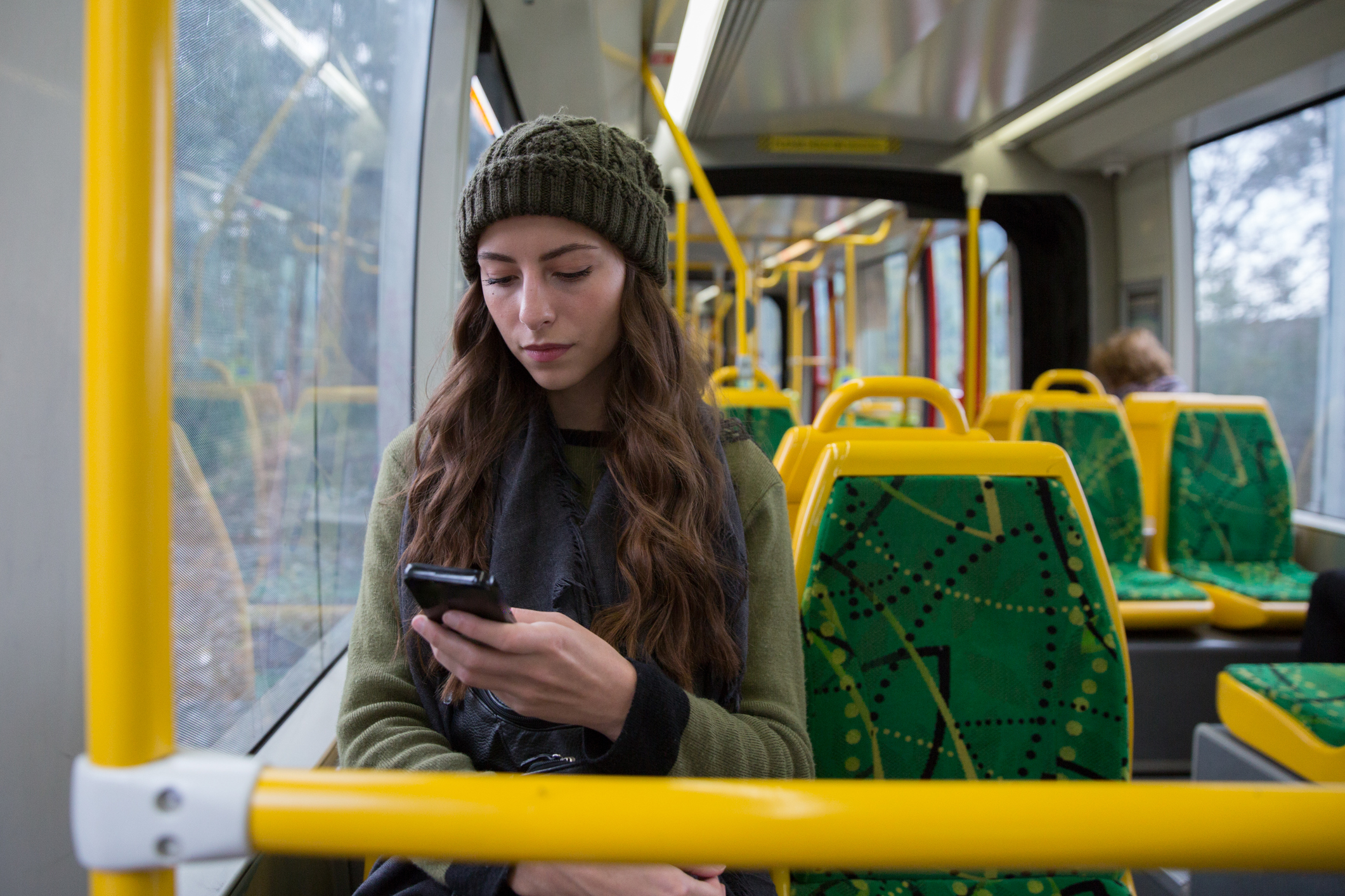 Close up shot of a young woman texting while she rides the tram in Melbourne