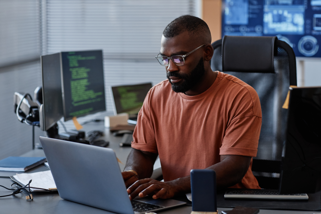 Man working on laptop solving information technology (IT) issues