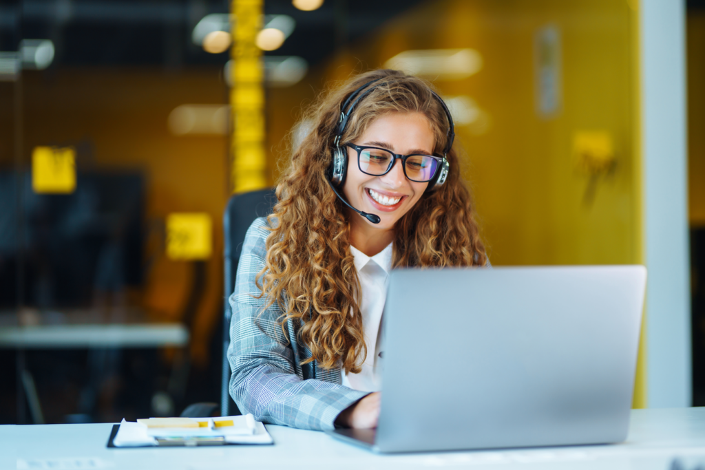 Woman working remotely on laptop with headset