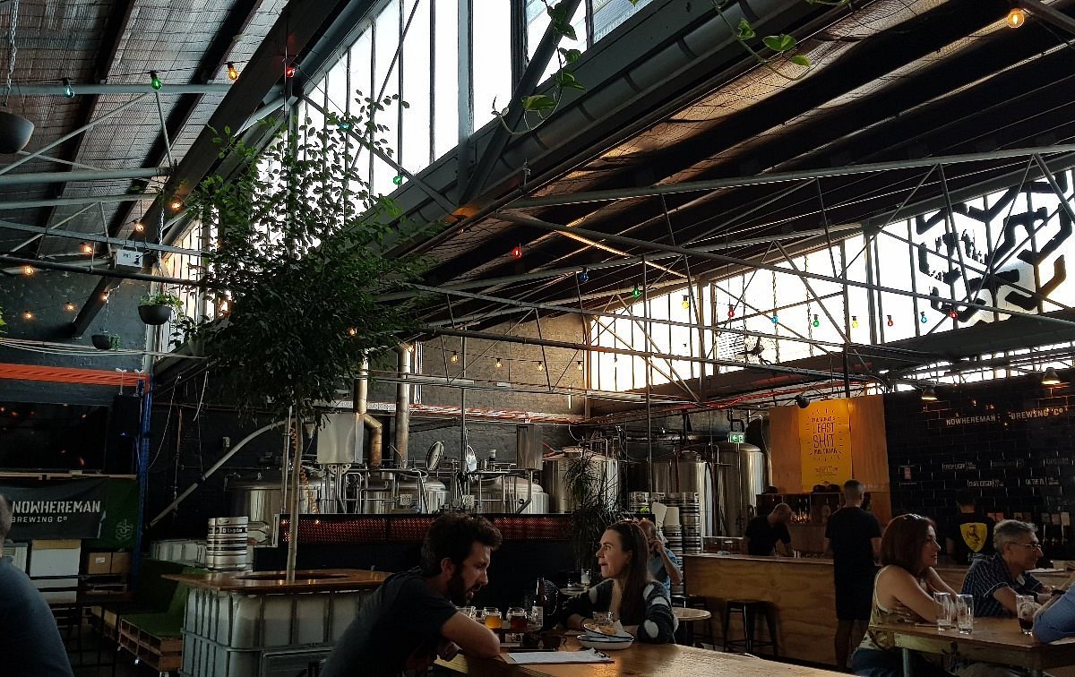 Photograph of Nowhereman Brewing Co venue with a few people enjoying drinks