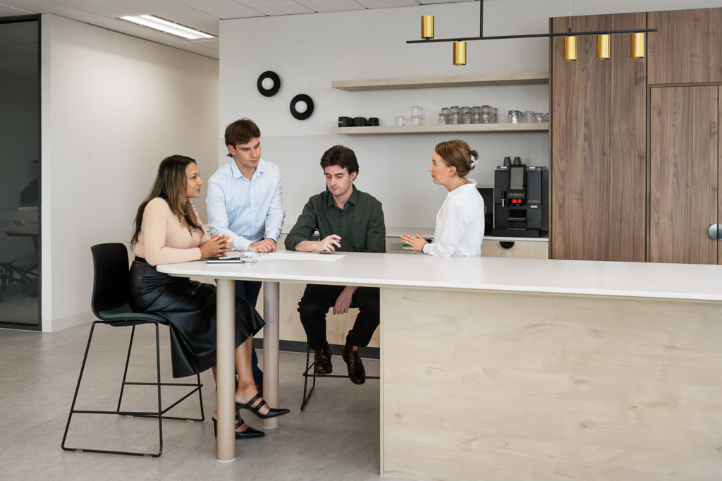 Group of diverse colleagues discussing business in the office cafeteria