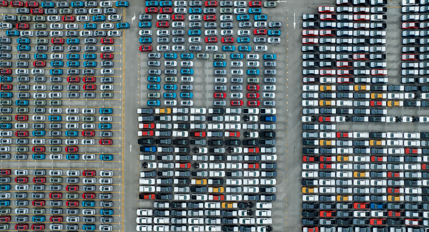 Rows of parked cars in a parking lot seen from above.