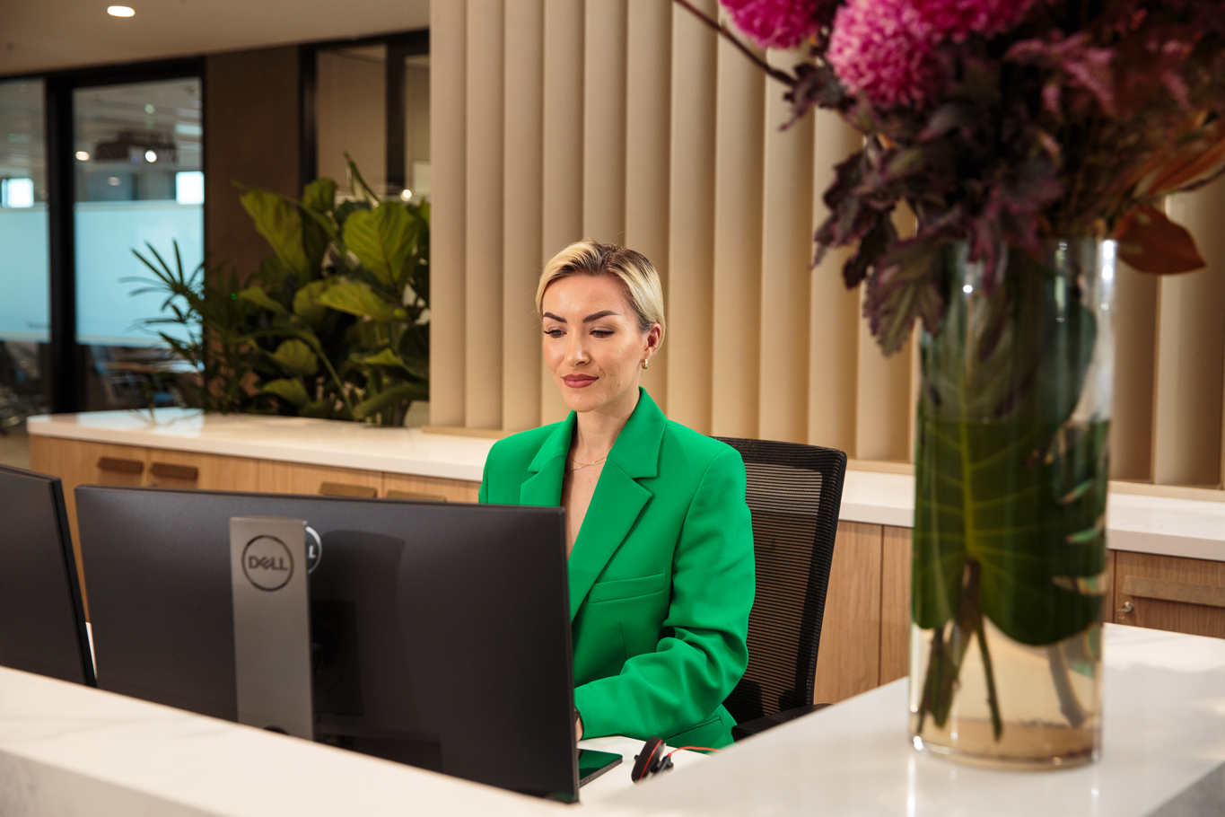 Female corporate working on computer at desk in modern office space