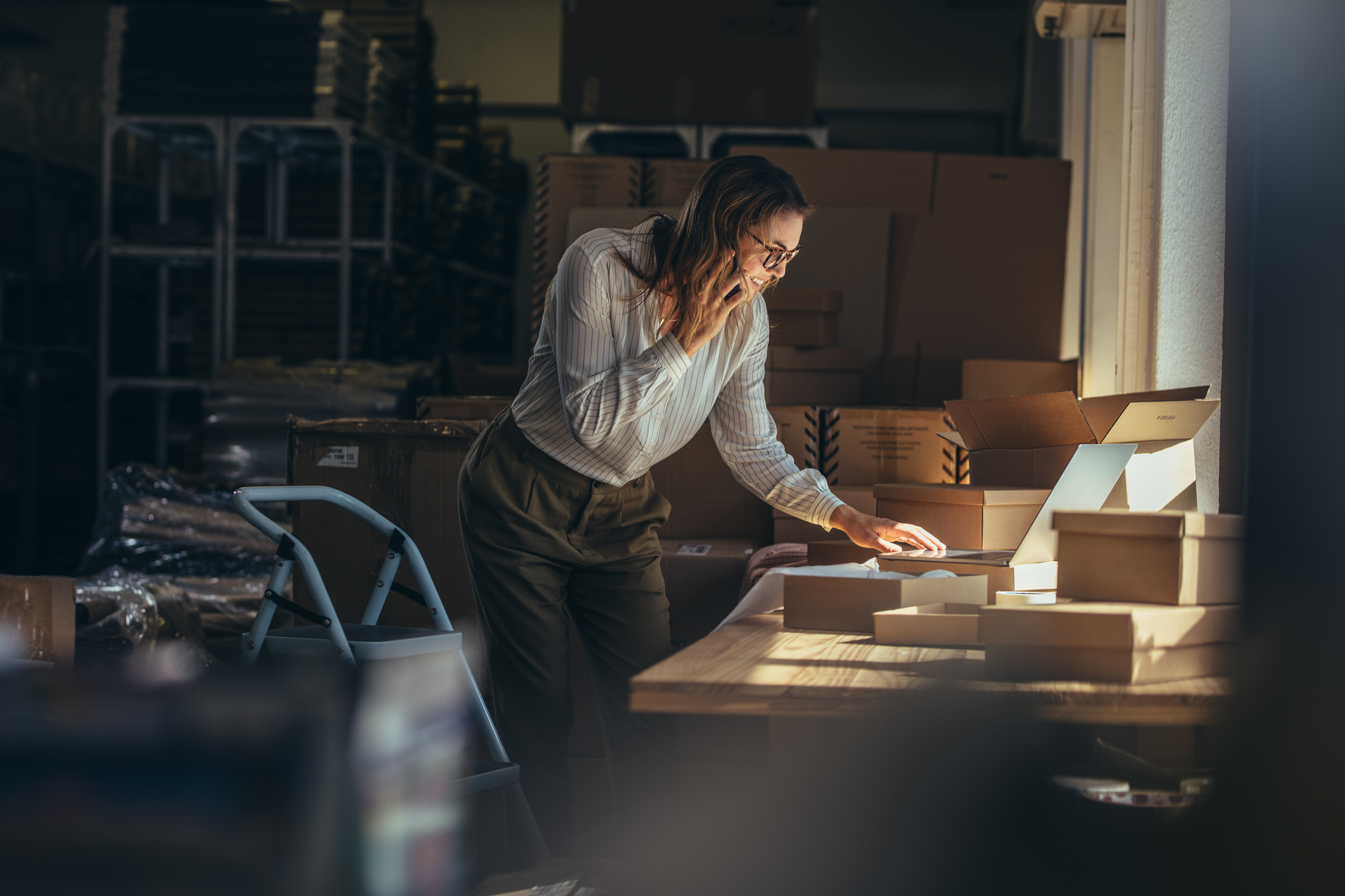 Online store businesswoman working on laptop and taking on the phone. Female business professional taking order on phone.