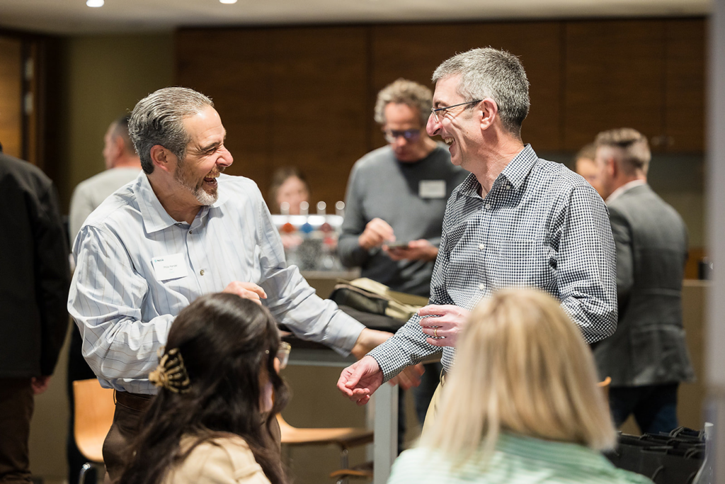 Two male Nexia employees laughing at internal Nexia conference