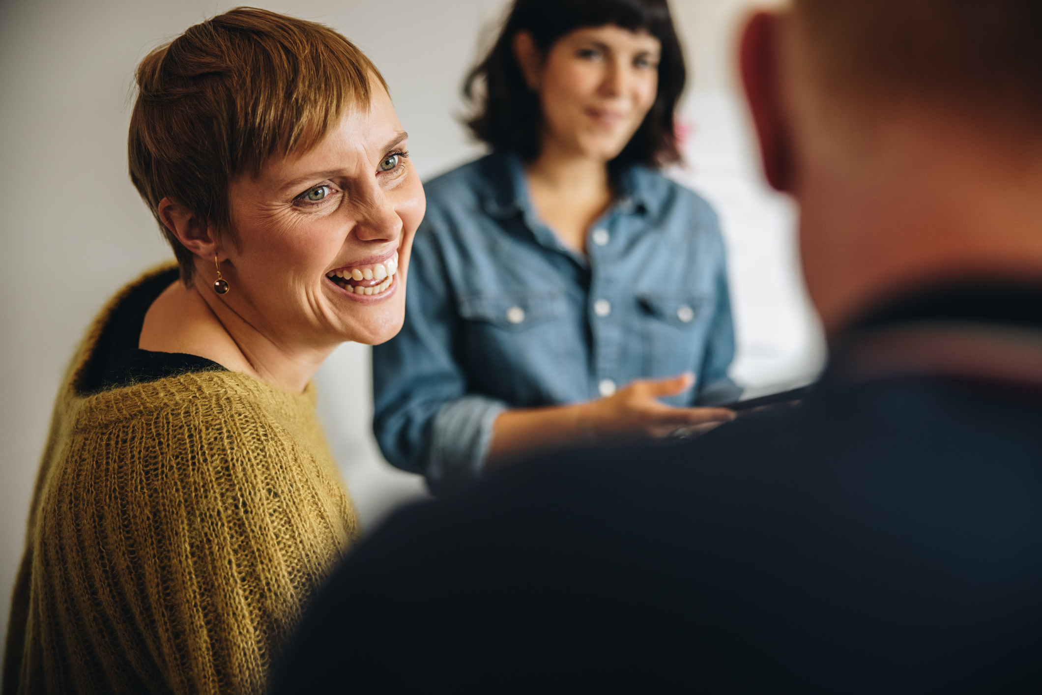 Businesswoman smiling during a meeting in office. Cheerful female professional looking at male colleague and smiling.